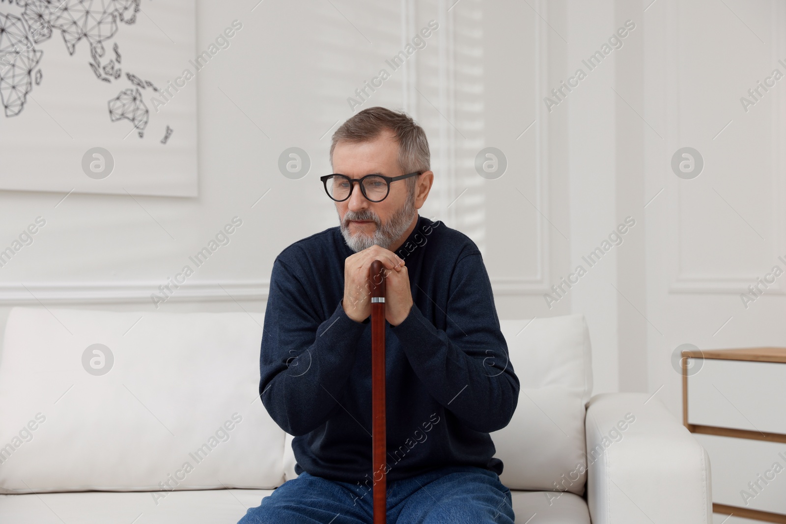 Photo of Mature man with walking cane at home