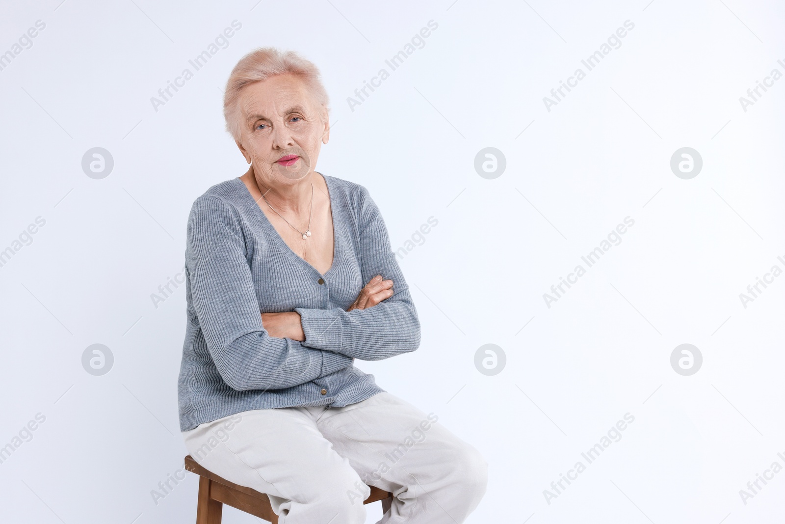 Photo of Senior woman on chair against white background. Space for text