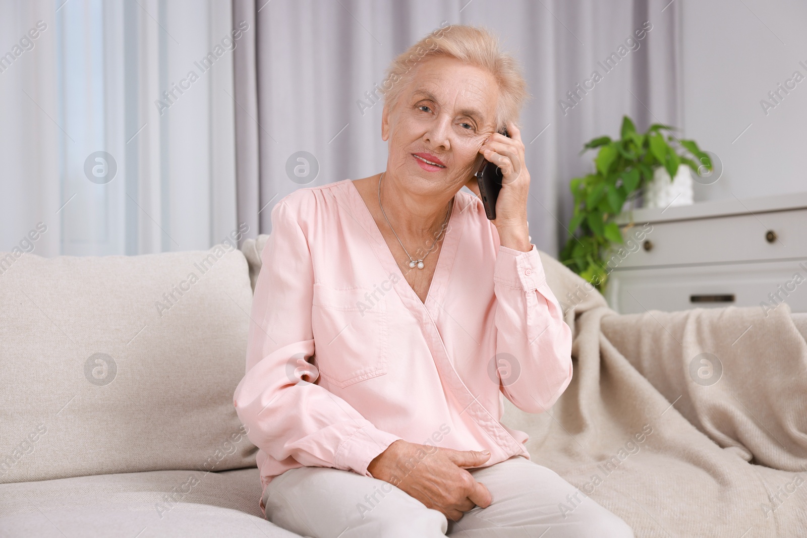 Photo of Senior woman talking on phone at home