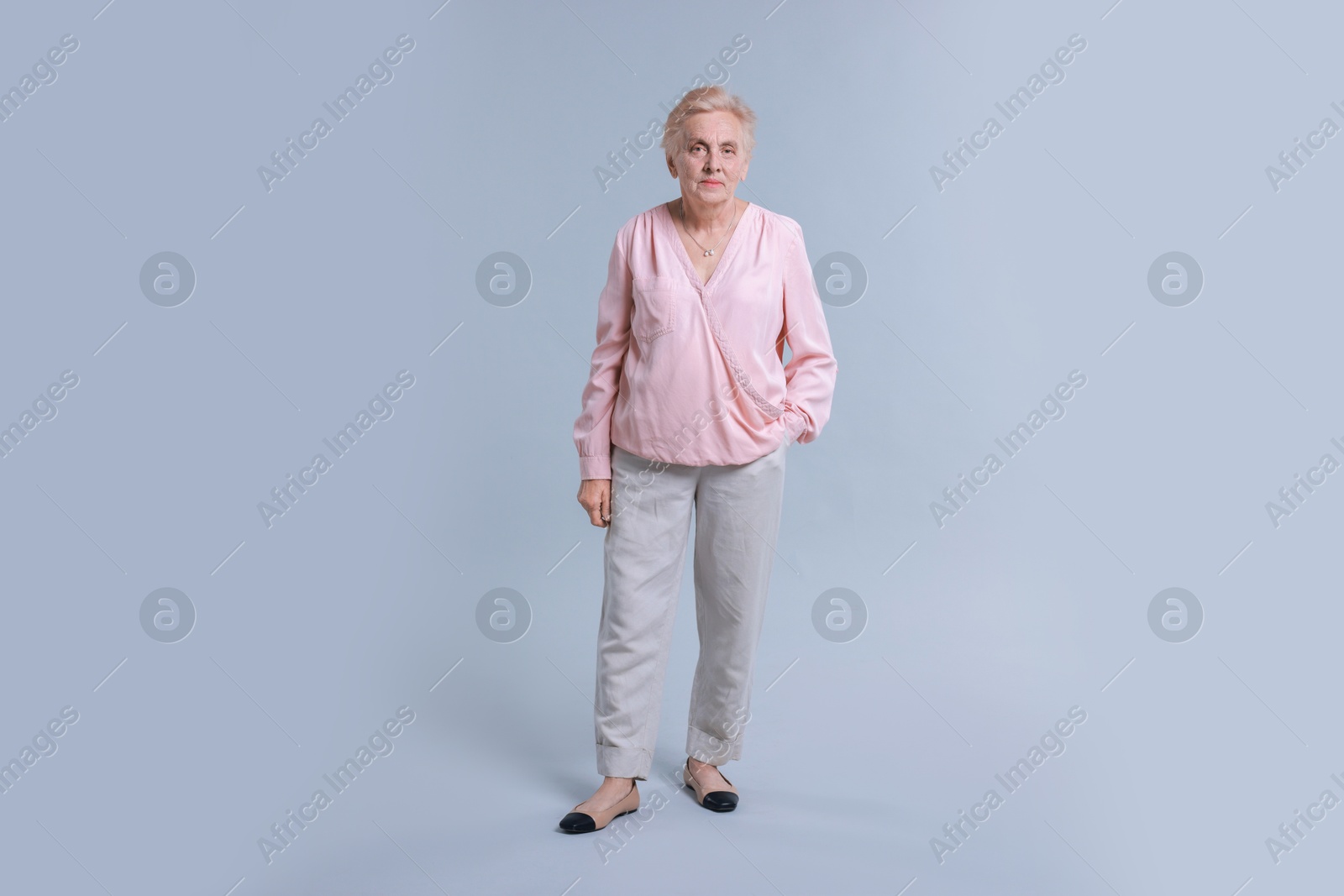 Photo of Full length portrait of senior woman on light background