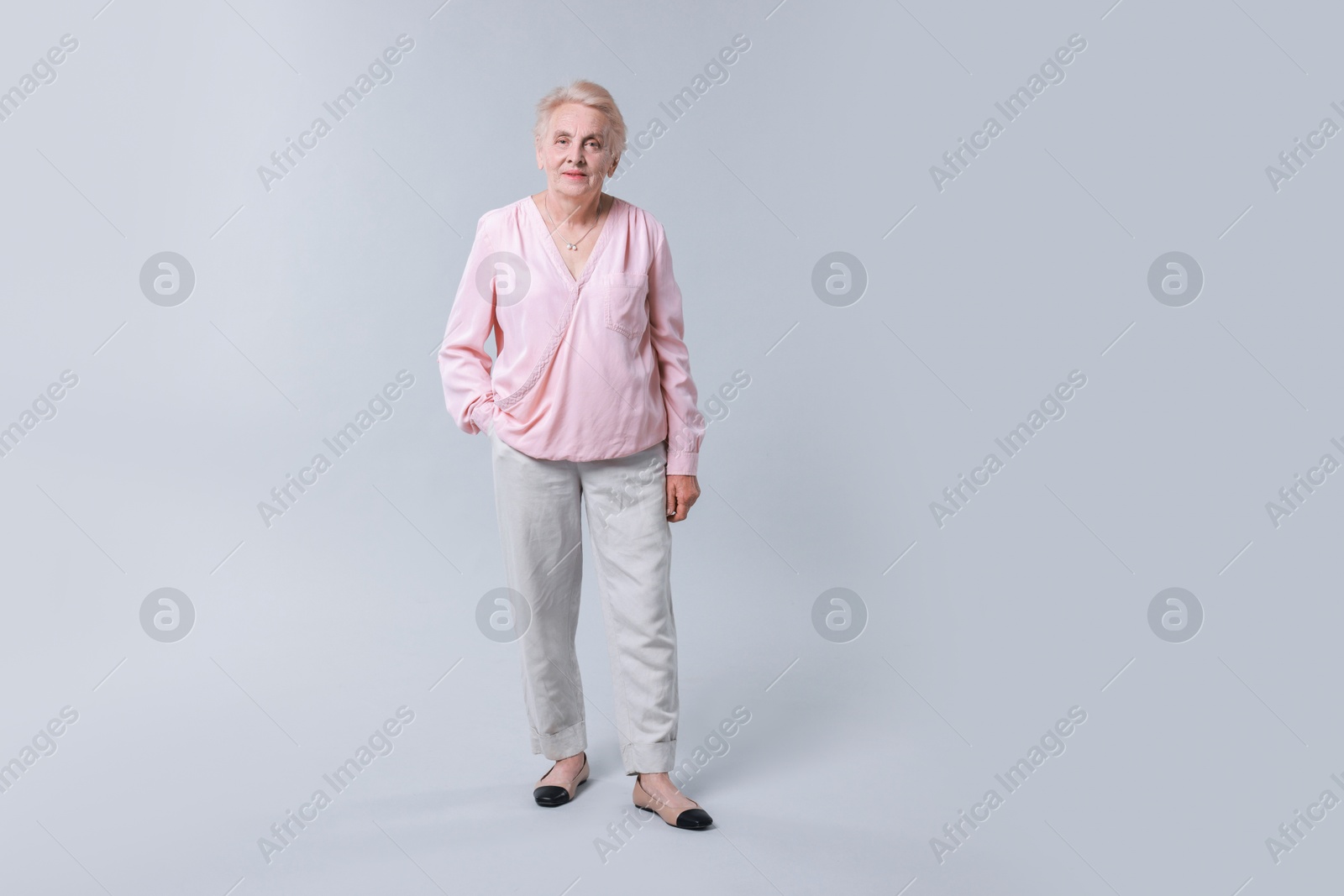 Photo of Full length portrait of senior woman on light background