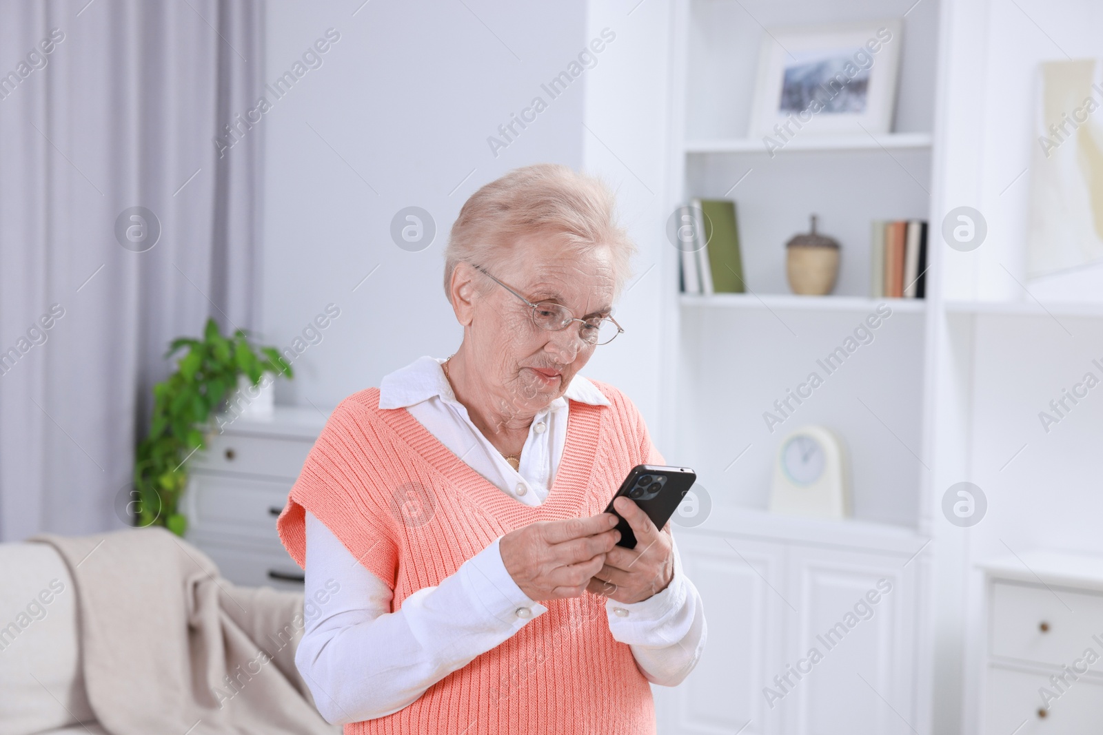 Photo of Senior woman using her smartphone at home