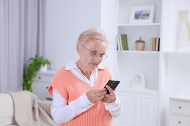 Photo of Senior woman using her smartphone at home