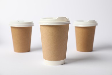 Photo of Paper cups on white background, selective focus. Mockup for design