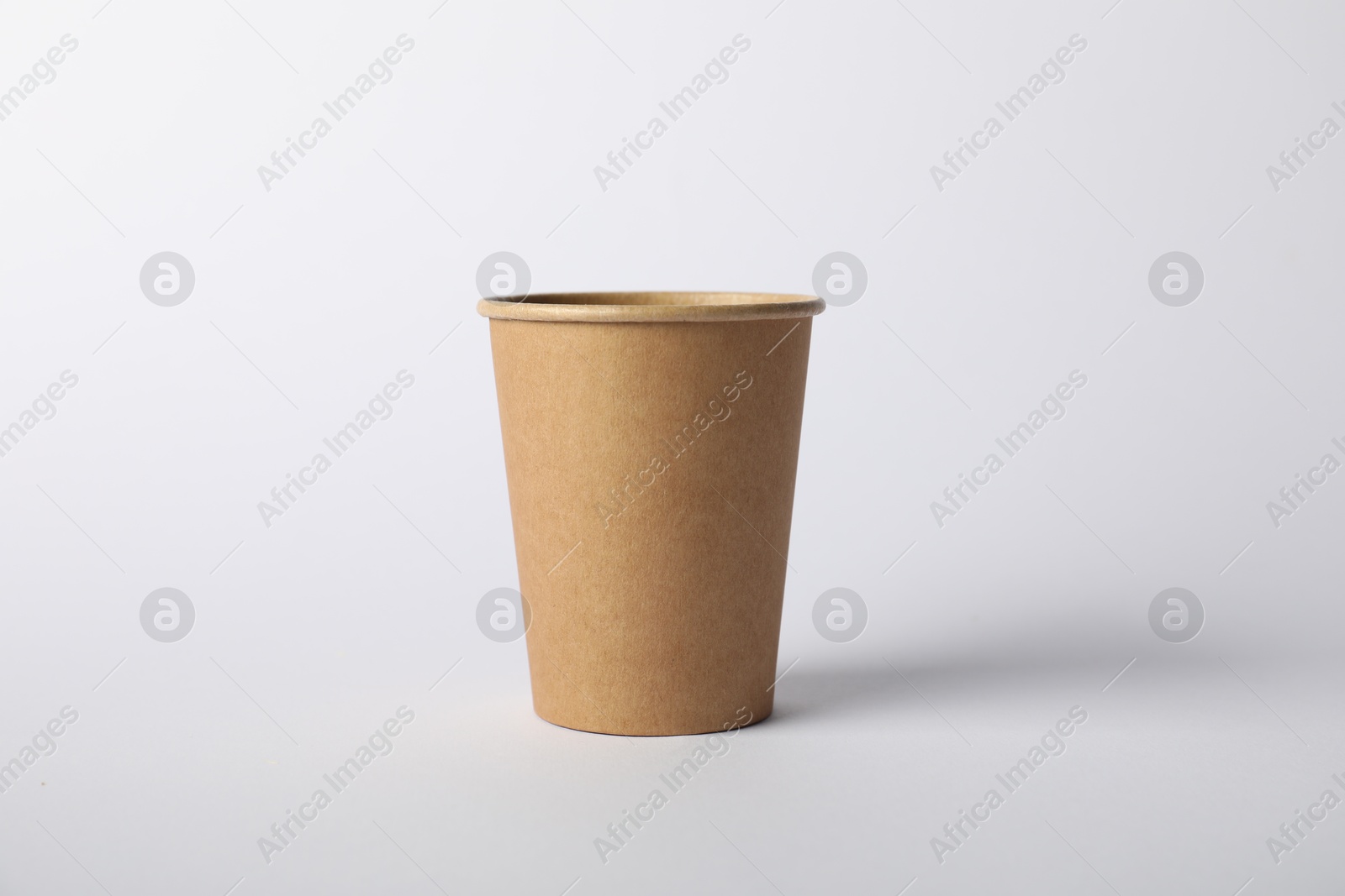 Photo of One paper cup on white background. Mockup for design