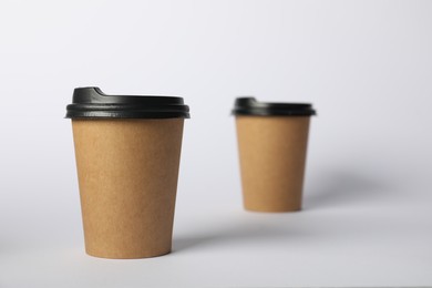 Photo of Paper cups with lids on white background, selective focus. Mockup for design