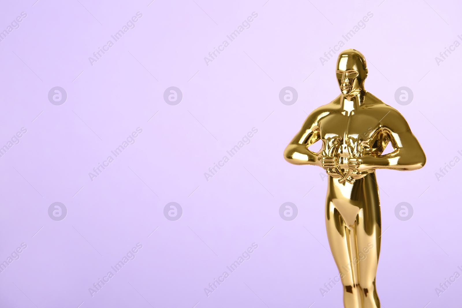 Photo of Golden trophy in shape of human figure on violet background, space for text