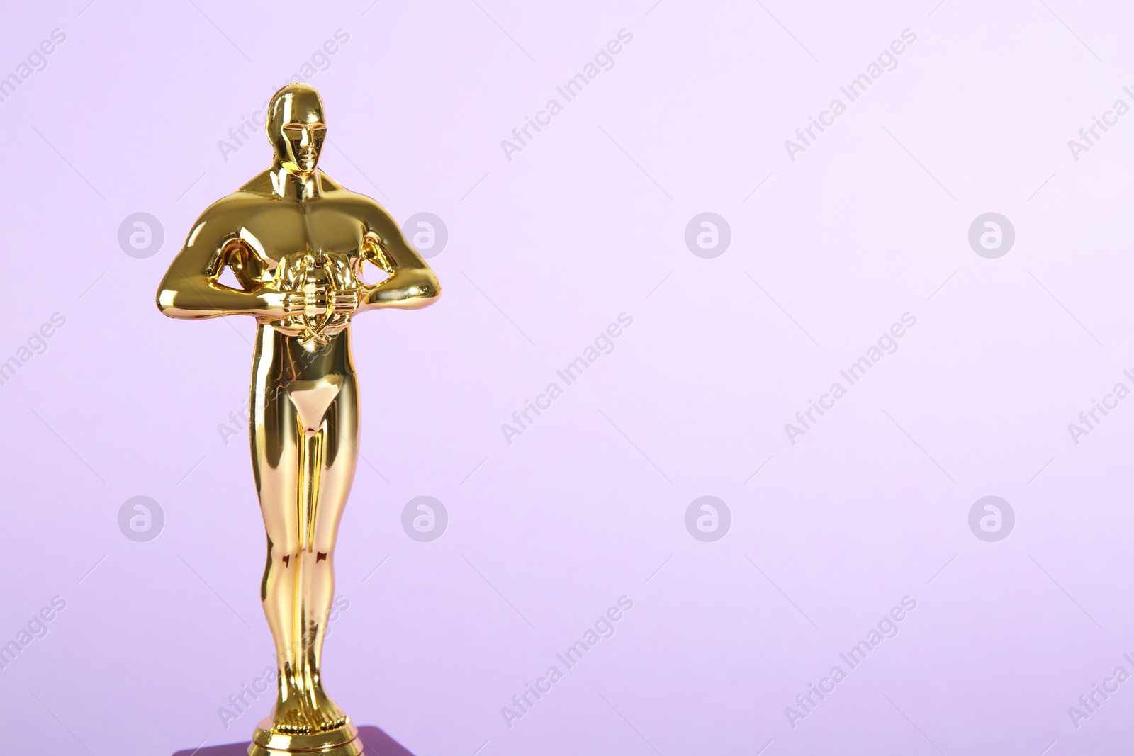 Photo of Golden trophy in shape of human figure on violet background, space for text