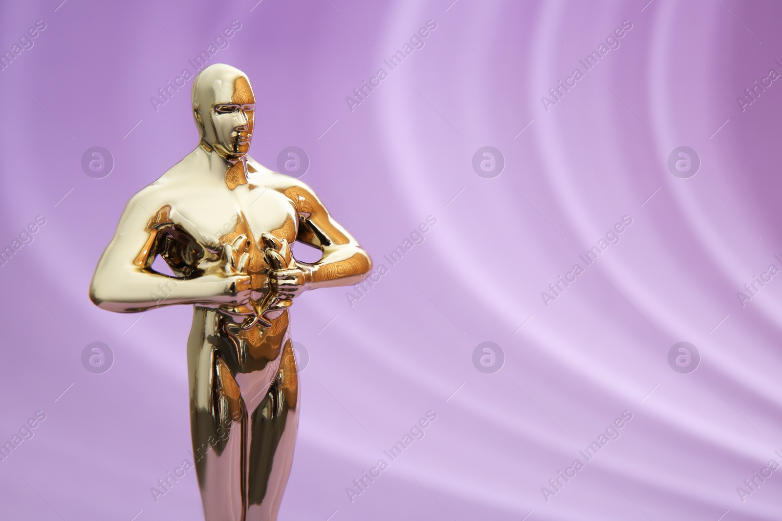 Photo of Golden trophy in shape of human figure on violet background, space for text