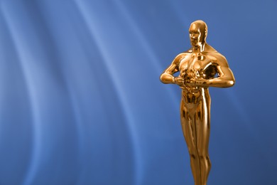 Photo of Golden trophy in shape of human figure on blue background, space for text