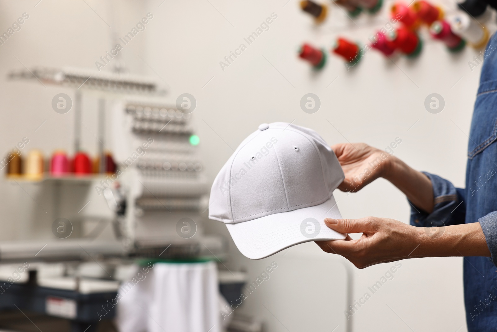 Photo of Woman with blank baseball cap for print indoors, closeup