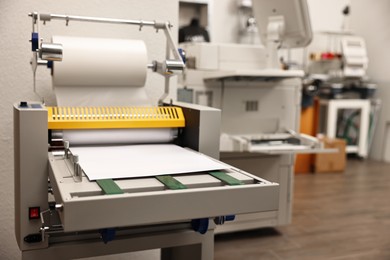 Photo of Modern roll laminator with paper indoors. Printing house