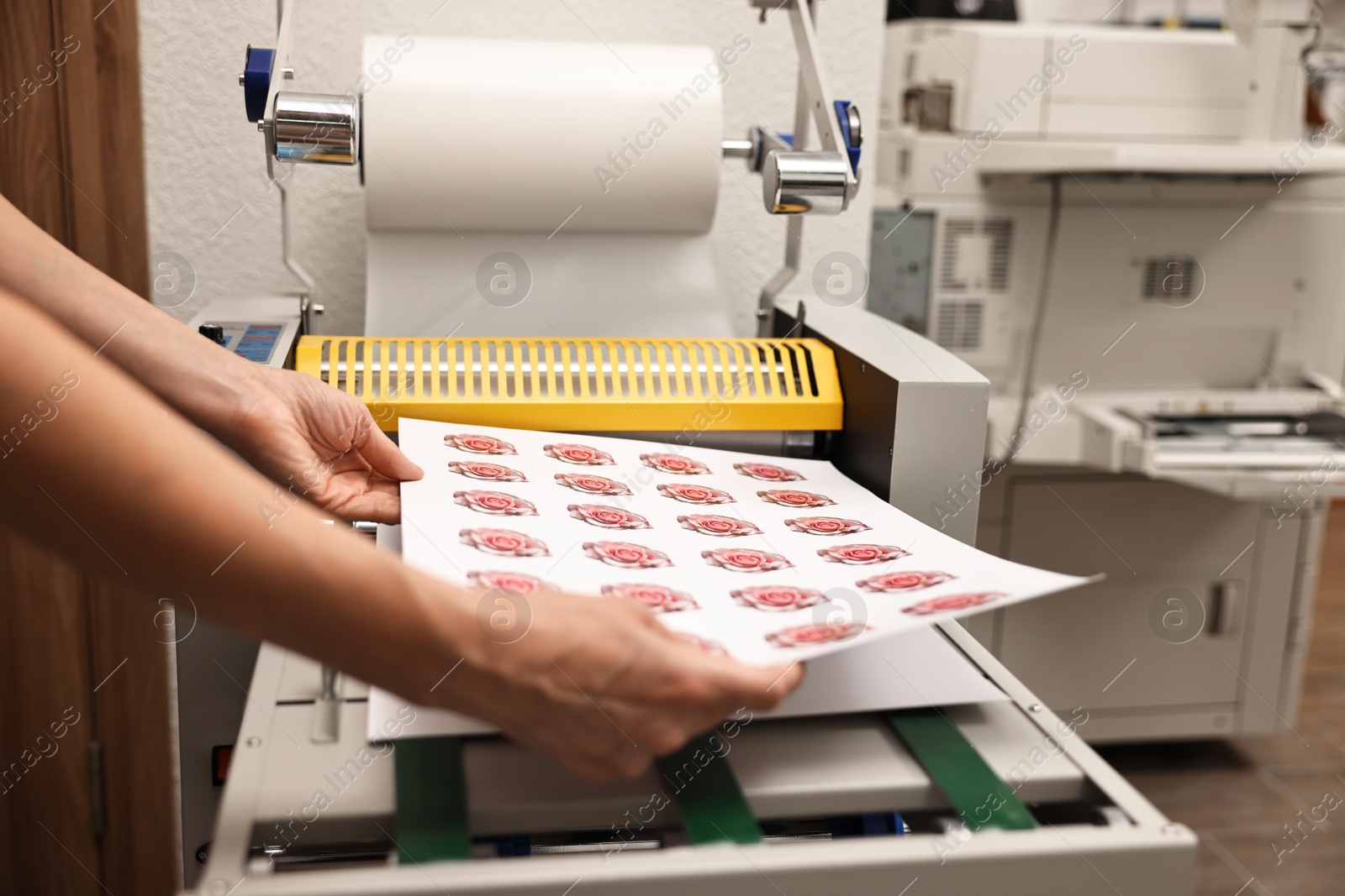 Photo of Woman with printed flower stickers indoors, closeup. Printing house