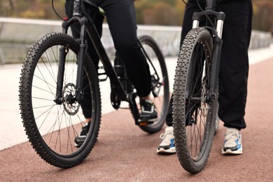 Photo of Couple with bicycles spending time together outdoors, closeup