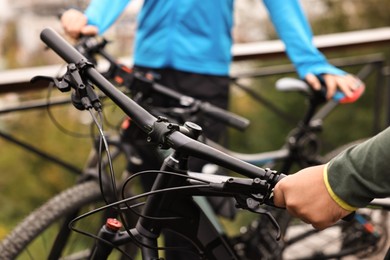 Couple with bicycles spending time together outdoors, closeup