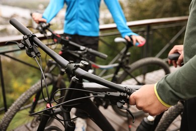 Photo of Couple with bicycles spending time together outdoors, closeup