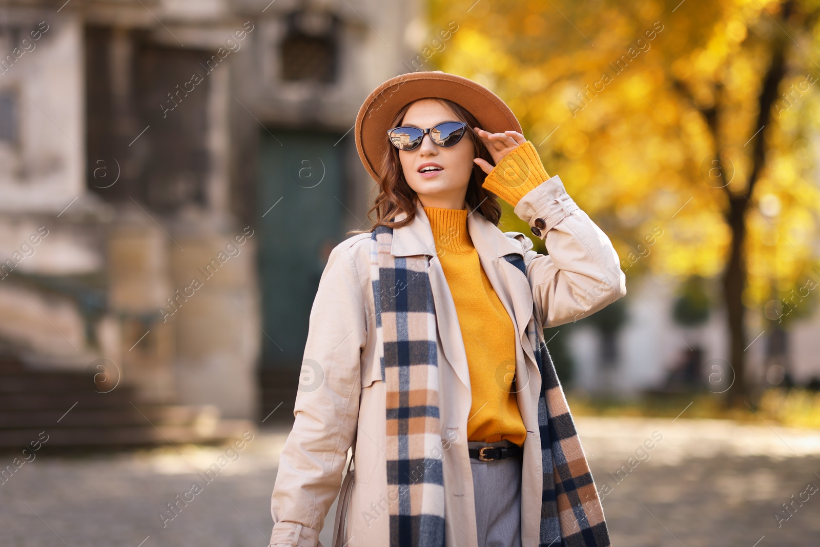 Photo of Charming young woman in stylish outfit on city street. Autumn season