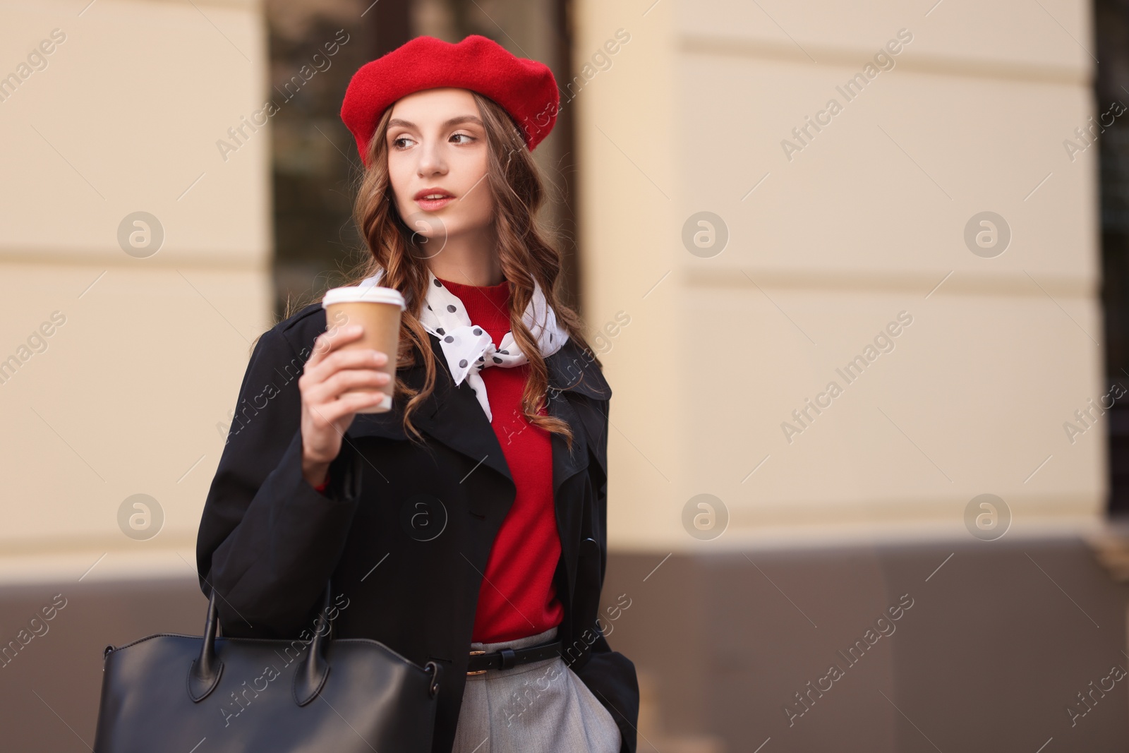 Photo of Stylish woman with cup of hot drink outdoors, space for text