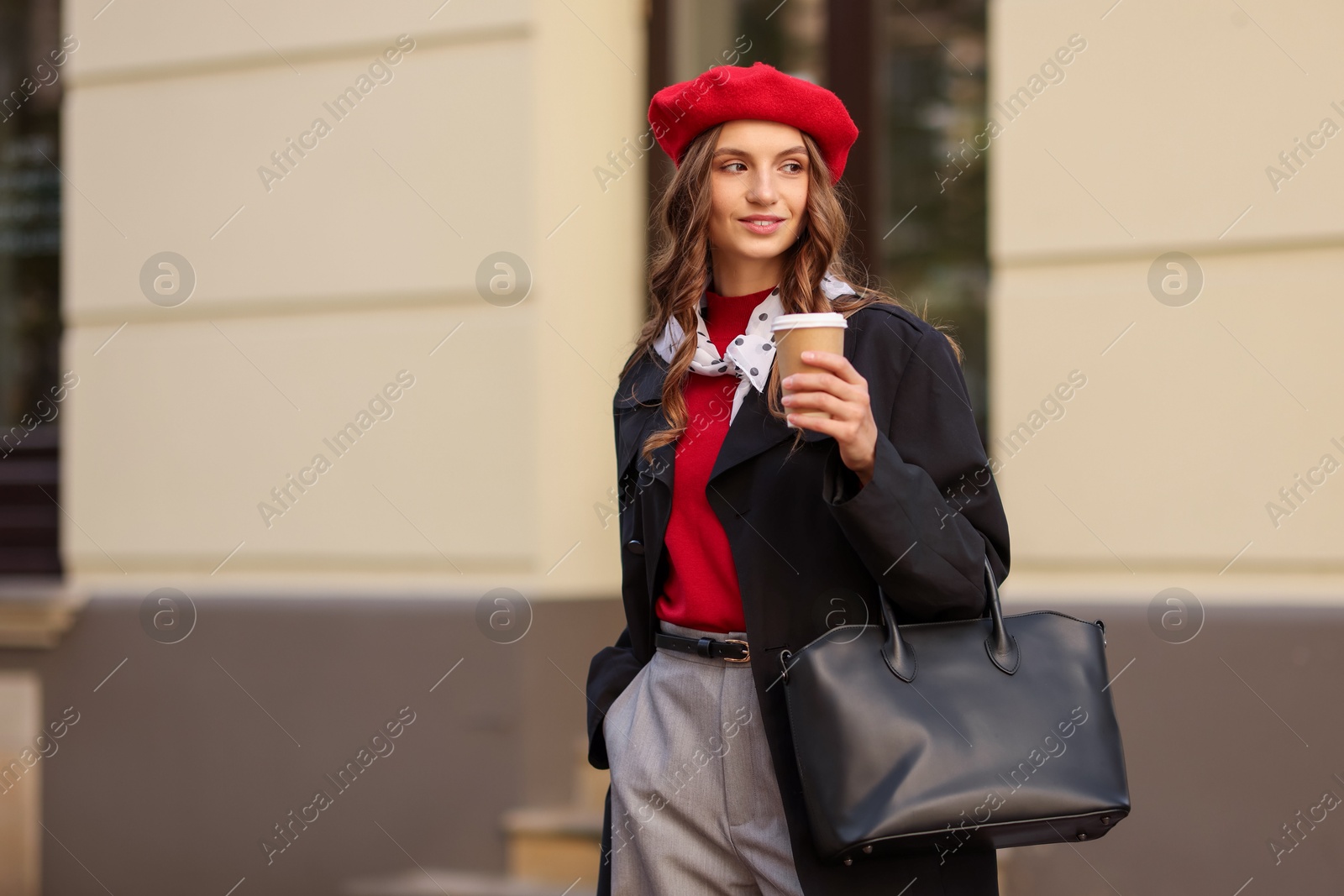 Photo of Stylish woman with cup of hot drink outdoors, space for text