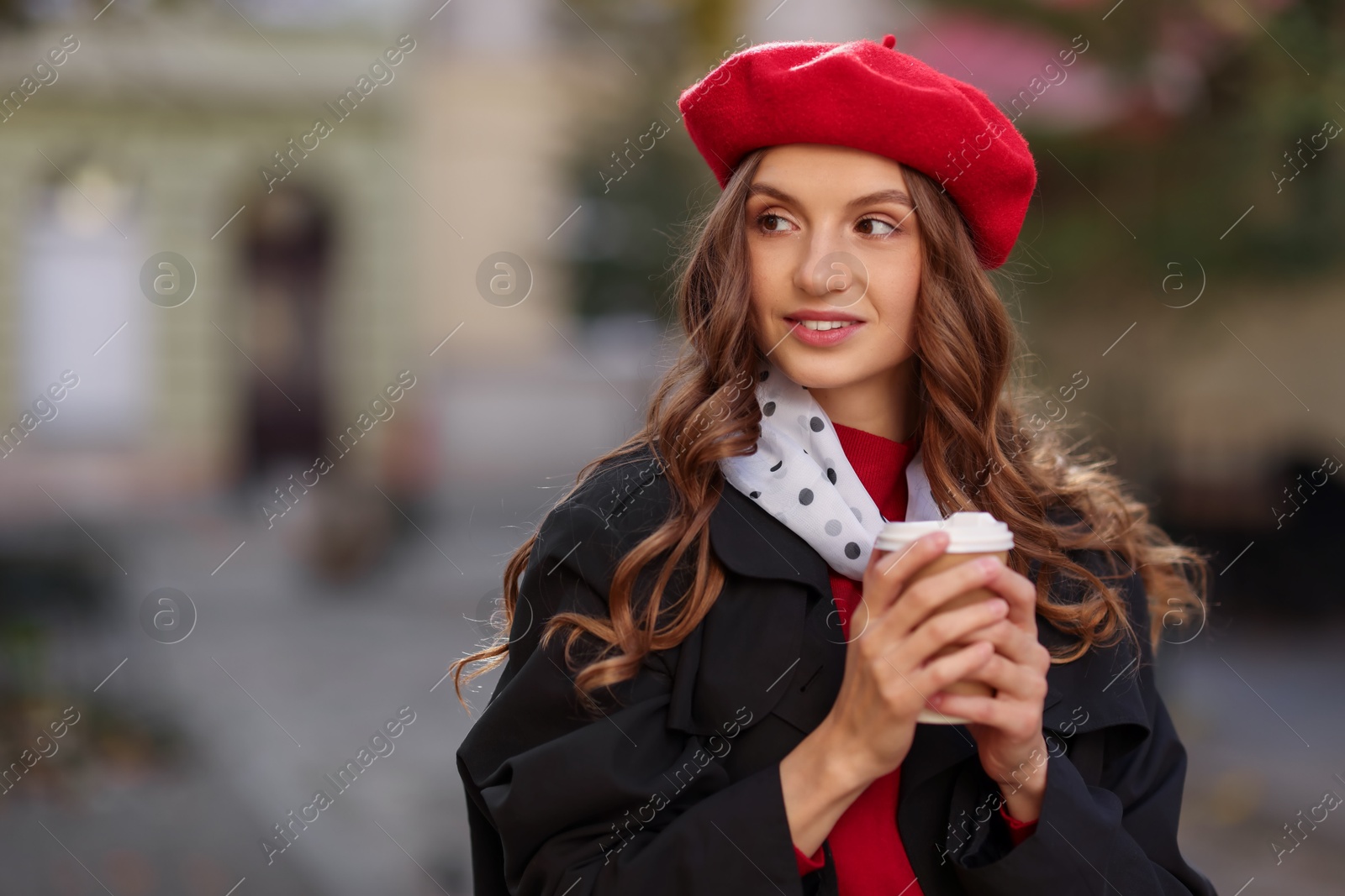 Photo of Stylish woman with cup of hot drink outdoors, space for text