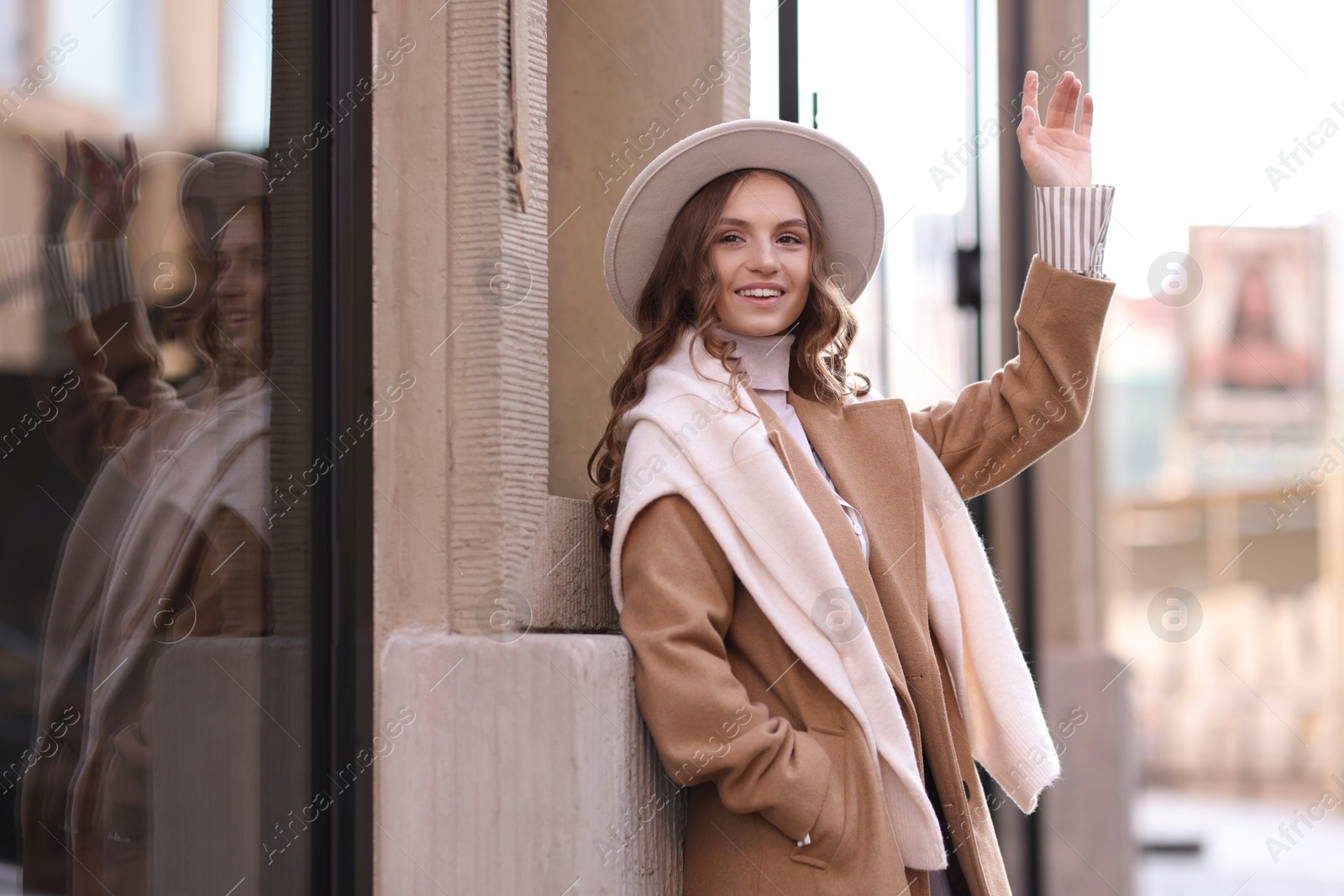 Photo of Charming young woman near shop on city street, space for text