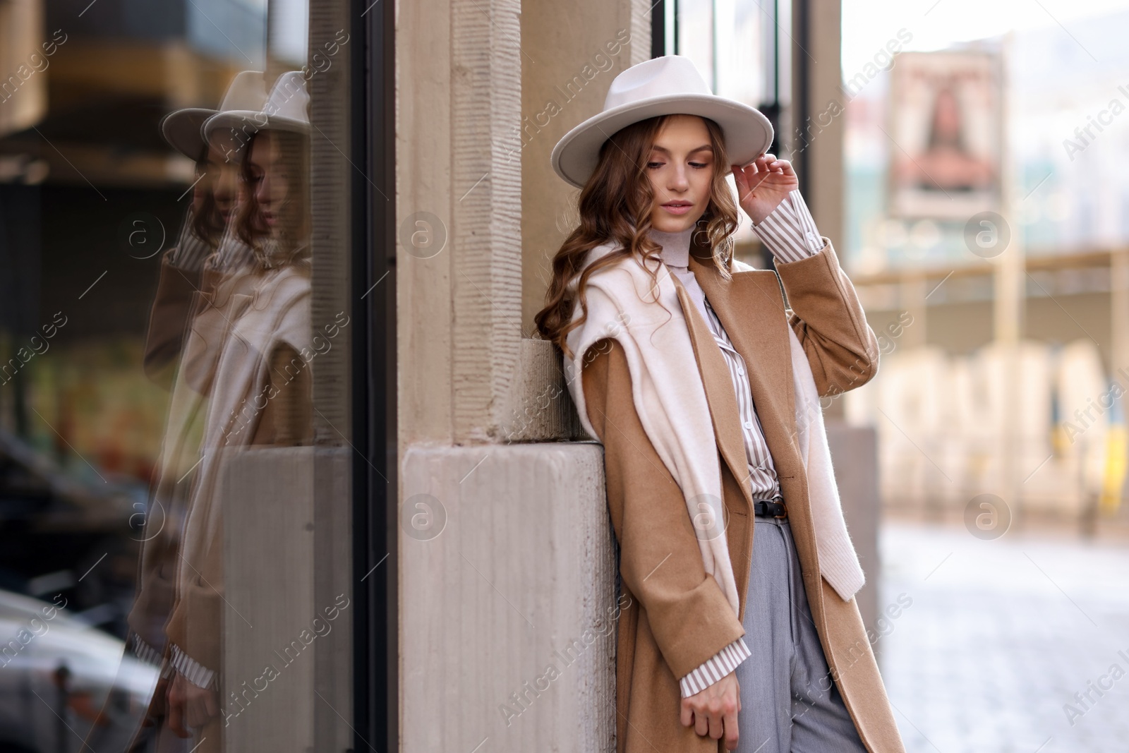 Photo of Charming young woman near shop on city street, space for text