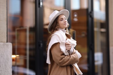 Photo of Charming young woman near shop on city street