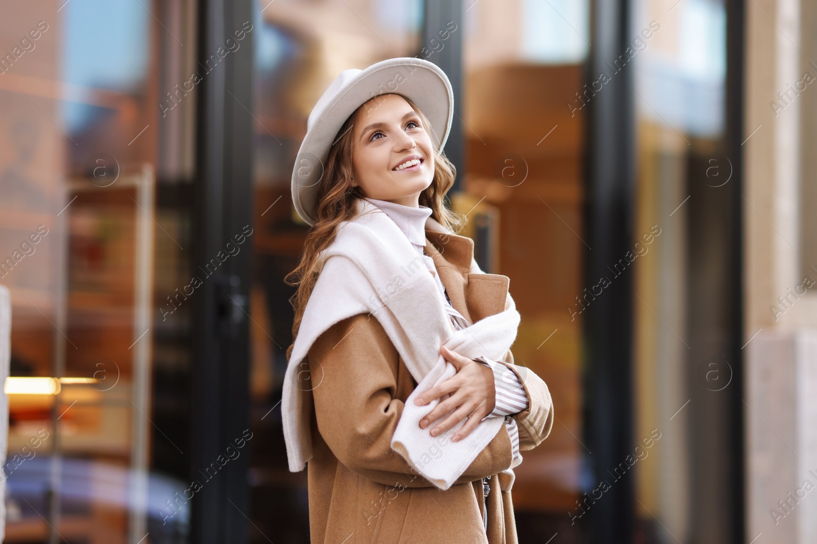 Photo of Charming young woman near shop on city street