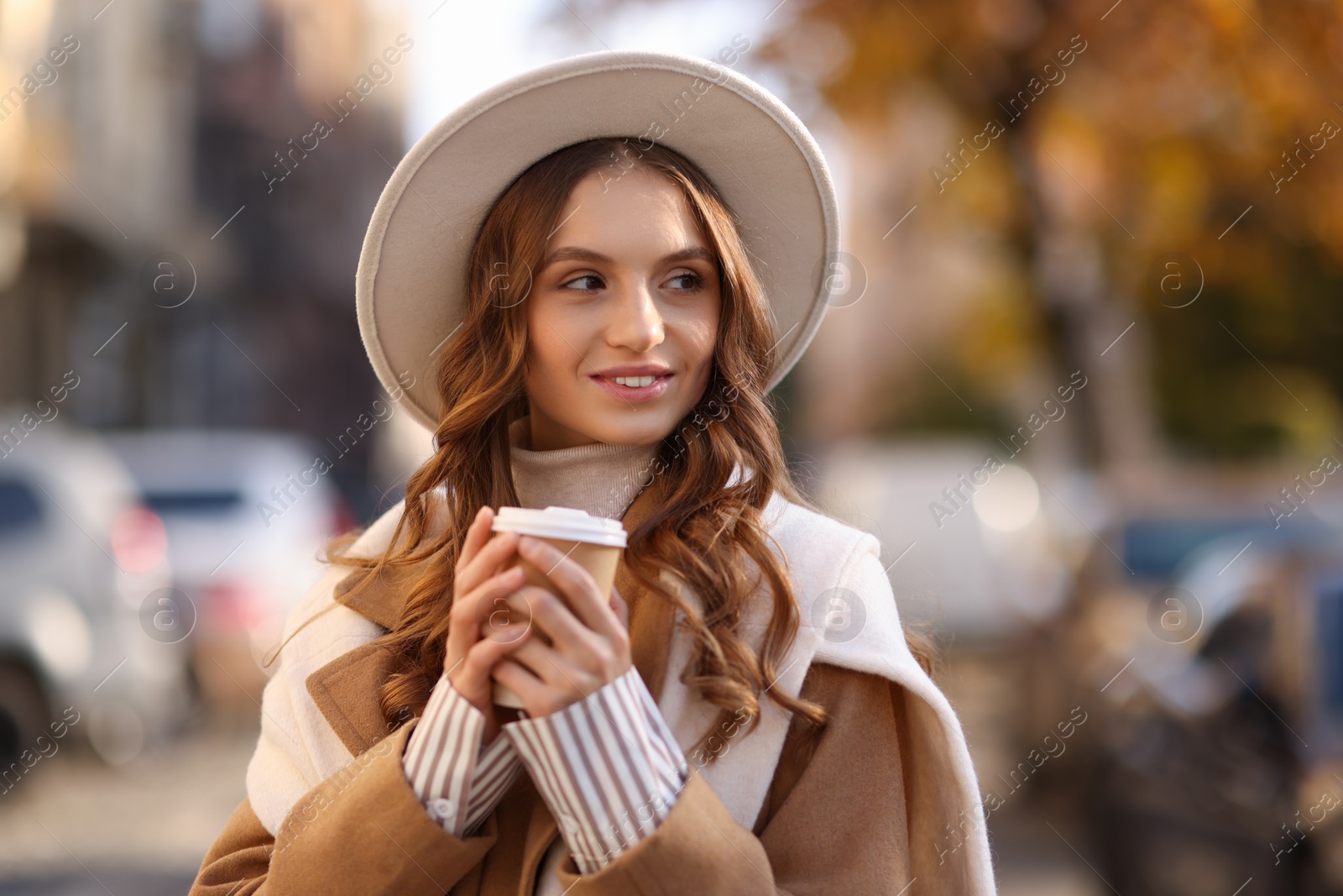 Photo of Stylish woman with cup of coffee outdoors. Autumn mood