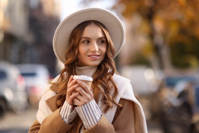 Photo of Stylish woman with cup of coffee outdoors. Autumn mood