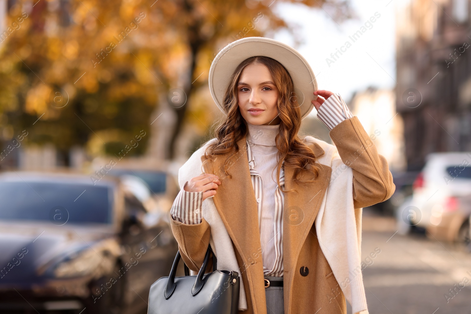 Photo of Young woman in beautiful outfit on city street. Autumn style