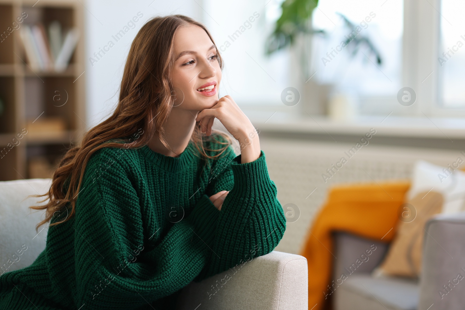 Photo of Charming young woman on sofa at home. Autumn atmosphere