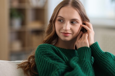 Photo of Charming young woman on sofa at home. Autumn atmosphere