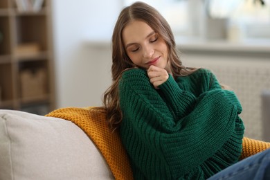 Photo of Charming young woman on sofa at home. Autumn atmosphere