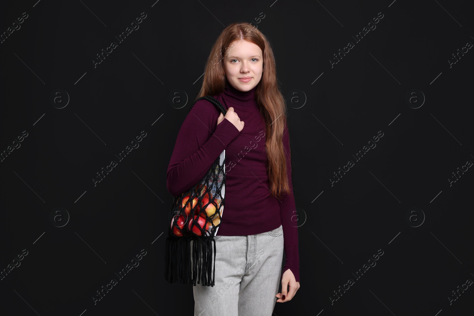 Photo of Teenage girl with handmade macrame bag on black background