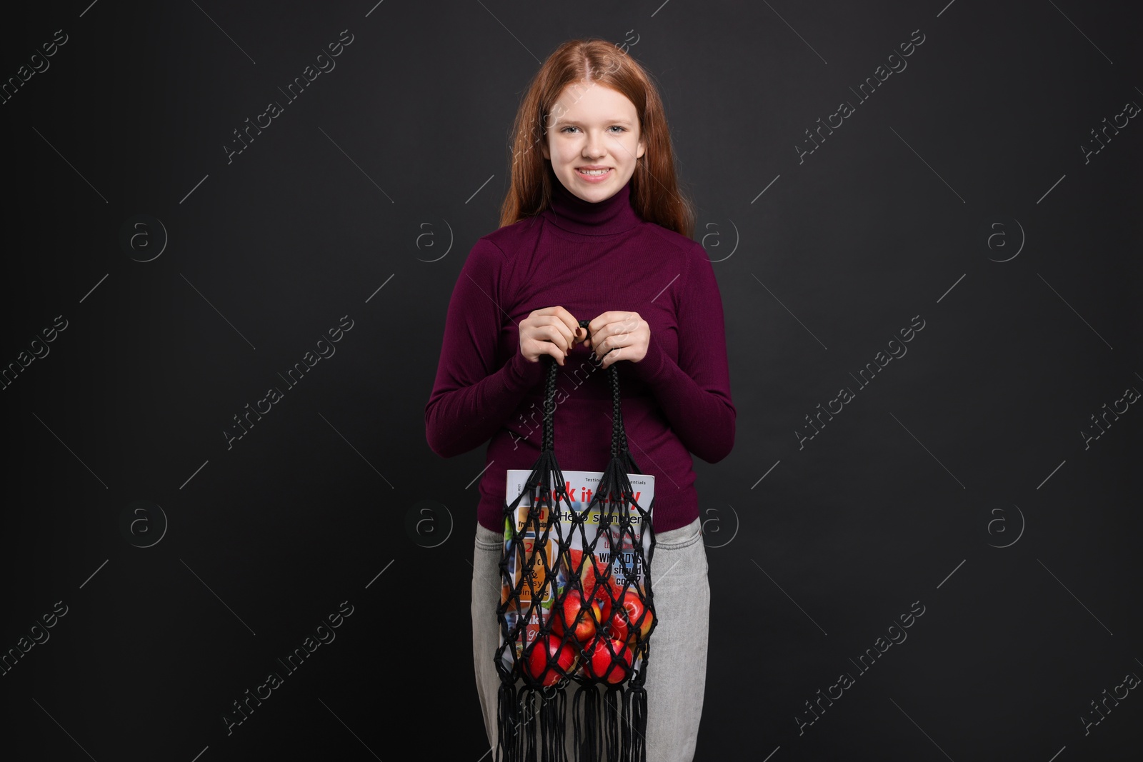 Photo of Teenage girl with handmade macrame bag on black background