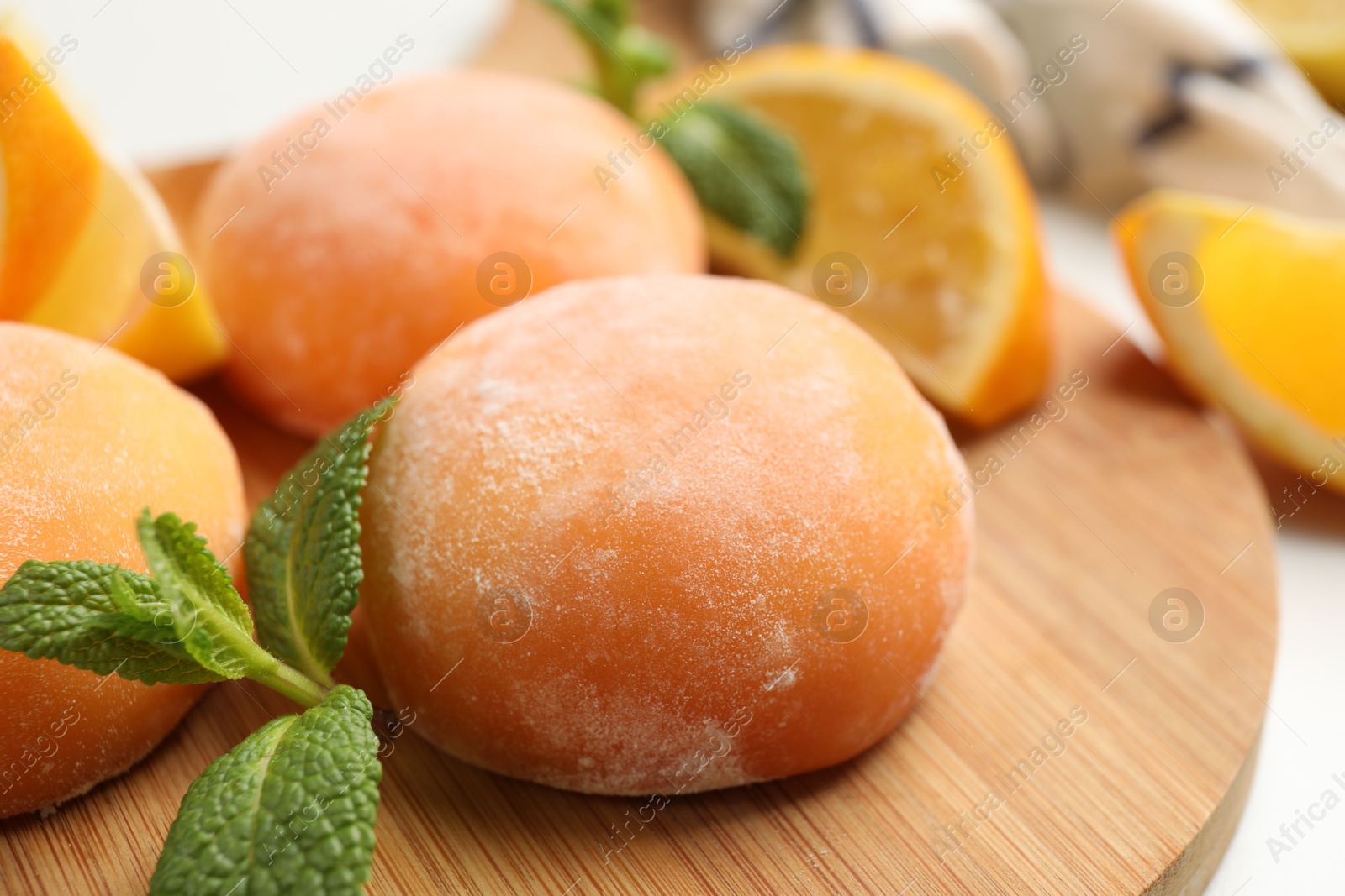 Photo of Board with tasty mochi and mint on table, closeup