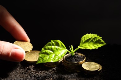 Photo of Money growth concept. Woman putting coins into soil with sprout, closeup. Space for text