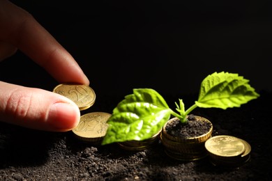 Photo of Money growth concept. Woman putting coins into soil with sprout, closeup. Space for text