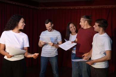 Photo of Professional actors with their scripts rehearsing in theatre