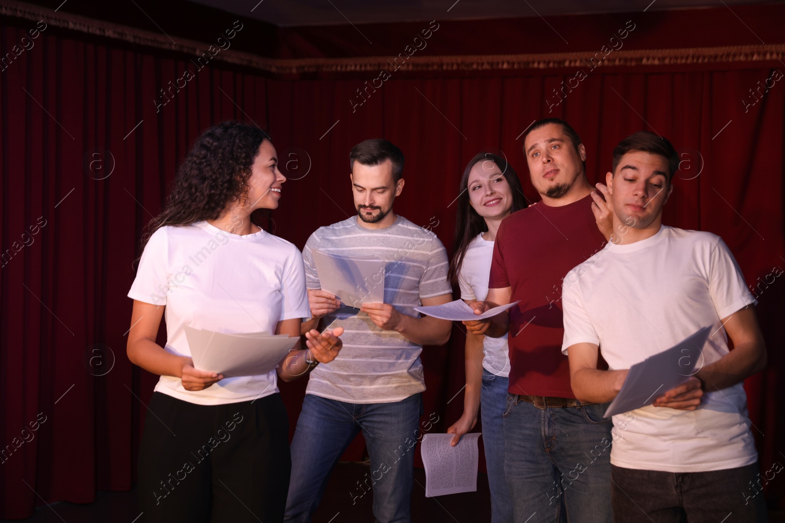 Photo of Professional actors with their scripts rehearsing in theatre