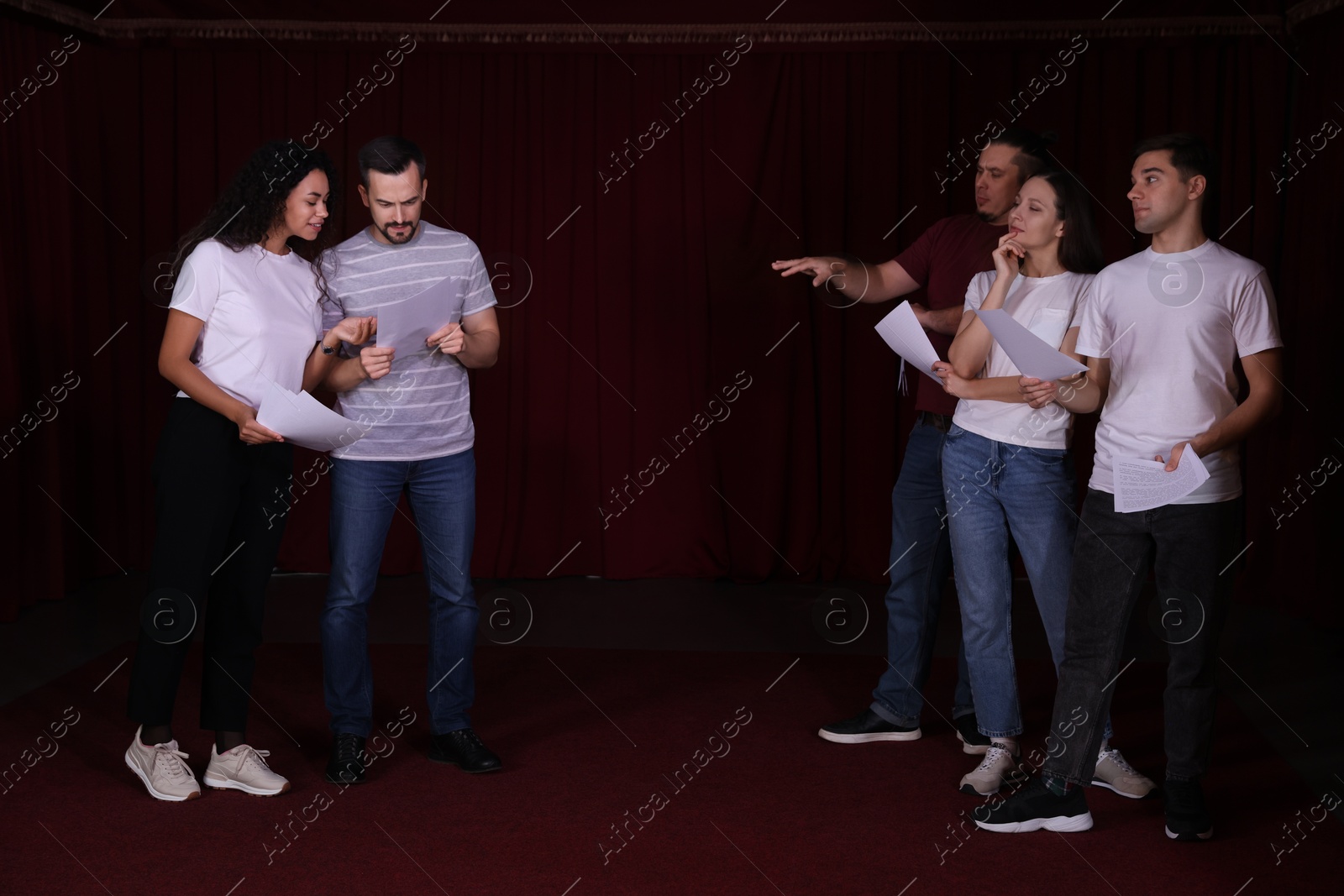 Photo of Professional actors with their scripts rehearsing in theatre