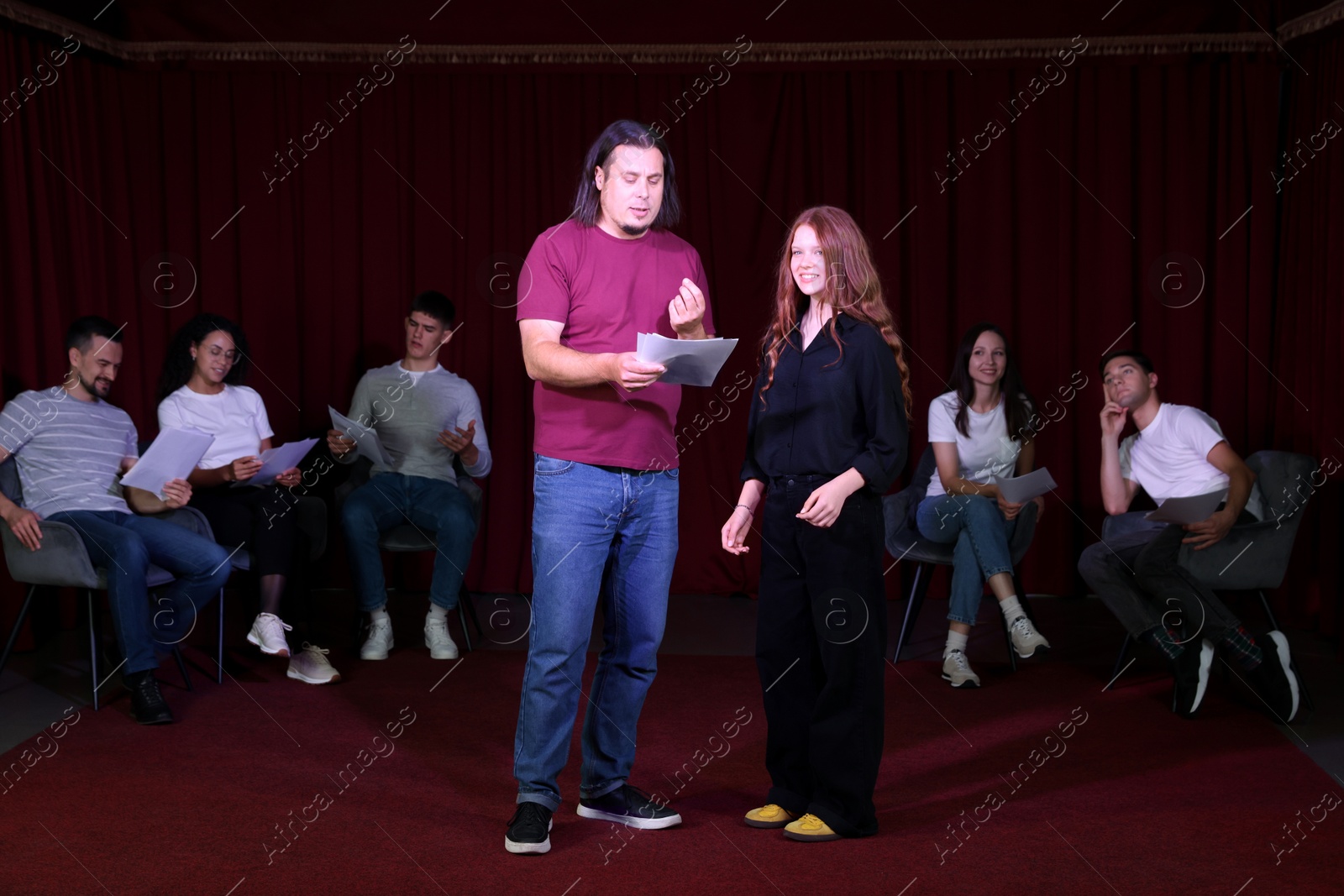 Photo of Professional actors with their scripts rehearsing in theatre