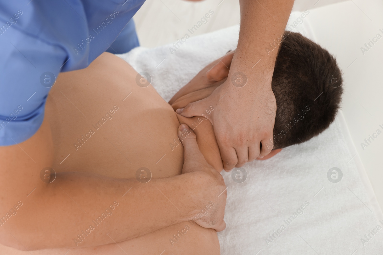 Photo of Osteopath massaging man's neck in clinic, closeup. Manual therapy