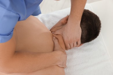 Photo of Osteopath massaging man's neck in clinic, closeup. Manual therapy