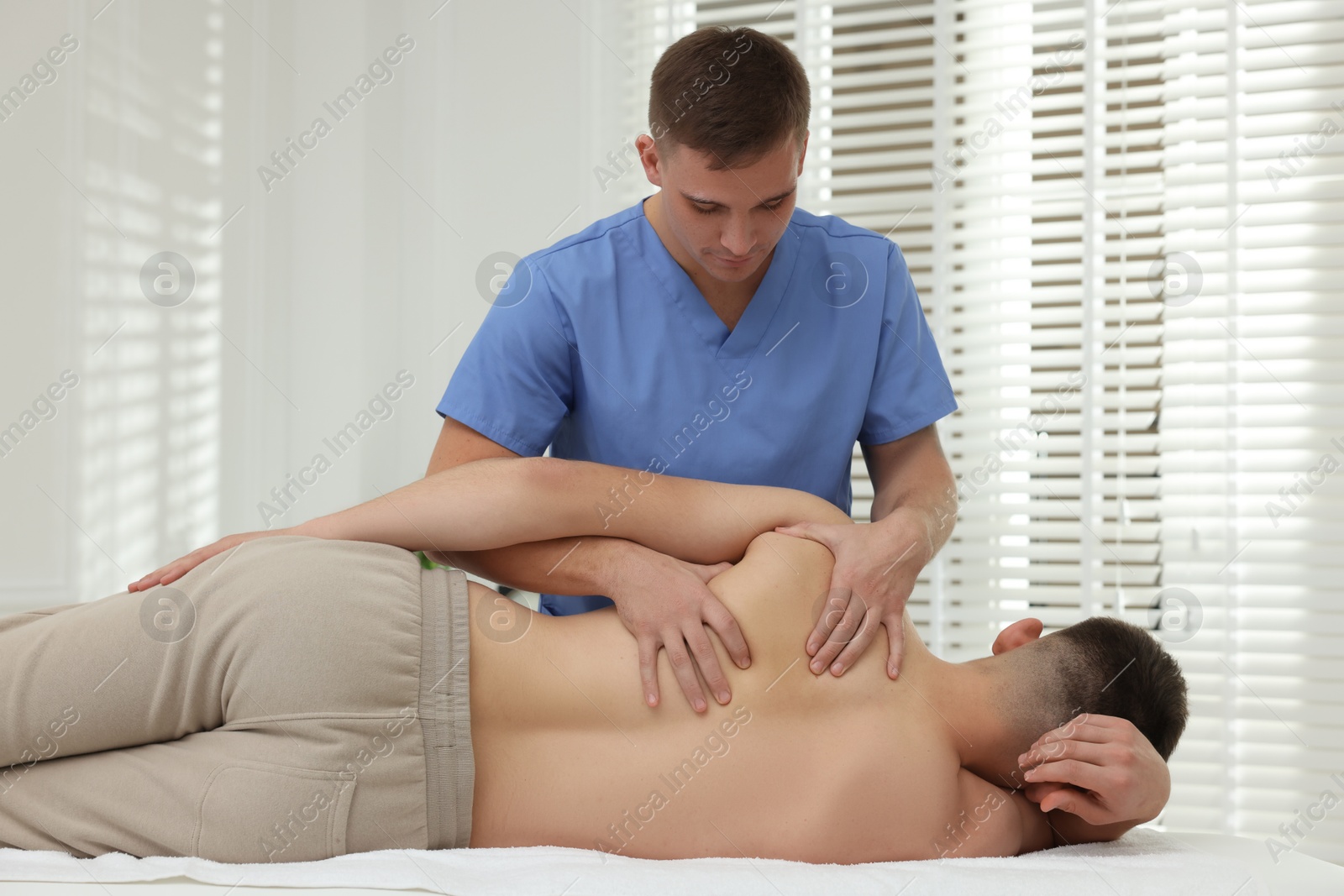 Photo of Osteopath working with patient in clinic. Manual therapy