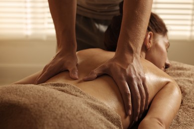 Osteopath massaging woman's back on couch indoors, closeup. Manual therapy