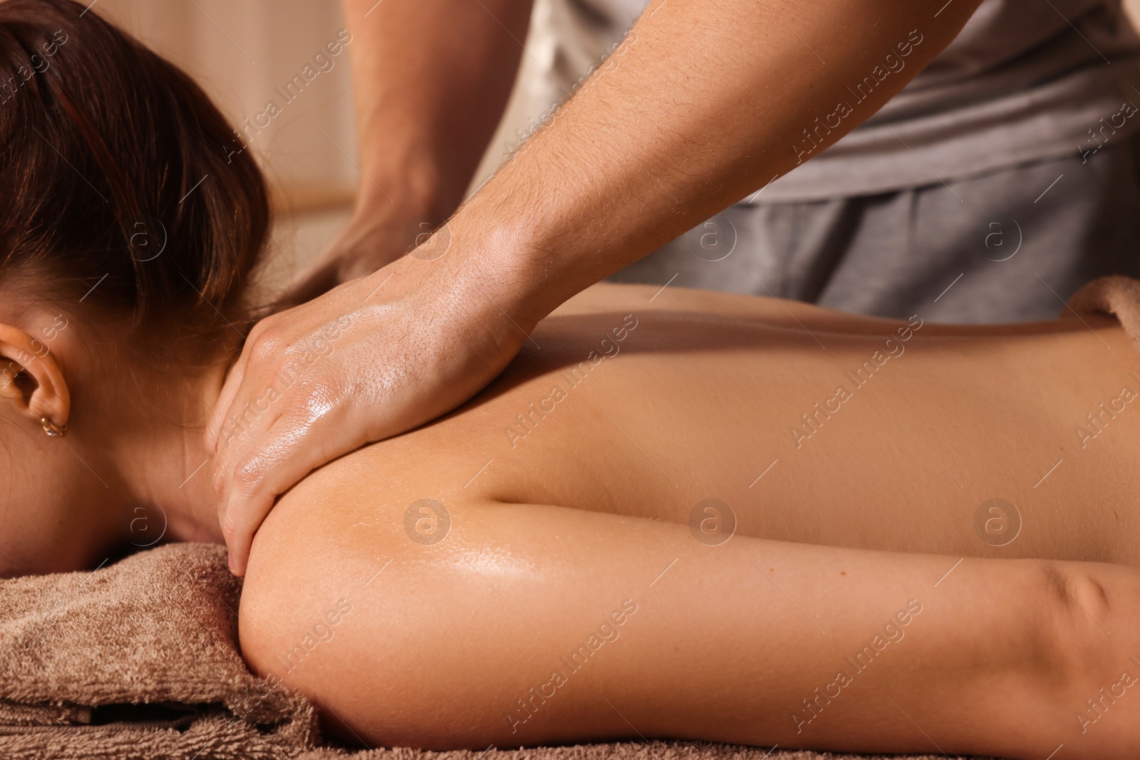 Photo of Osteopath massaging woman's back on couch indoors, closeup. Manual therapy