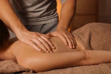 Osteopath massaging woman's back on couch indoors, closeup. Manual therapy