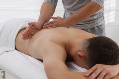 Massage therapist working with patient in clinic, closeup